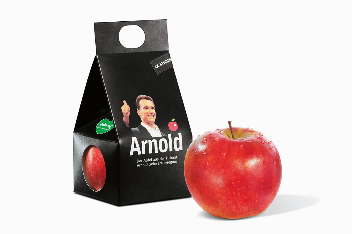 Auf diesem Bild ist der Apfel aus der Heimat Arnold Schwarzeneggers zu sehen. Dahinter befindet sich ein weiterer Apfel in einer schicken Verpackung.