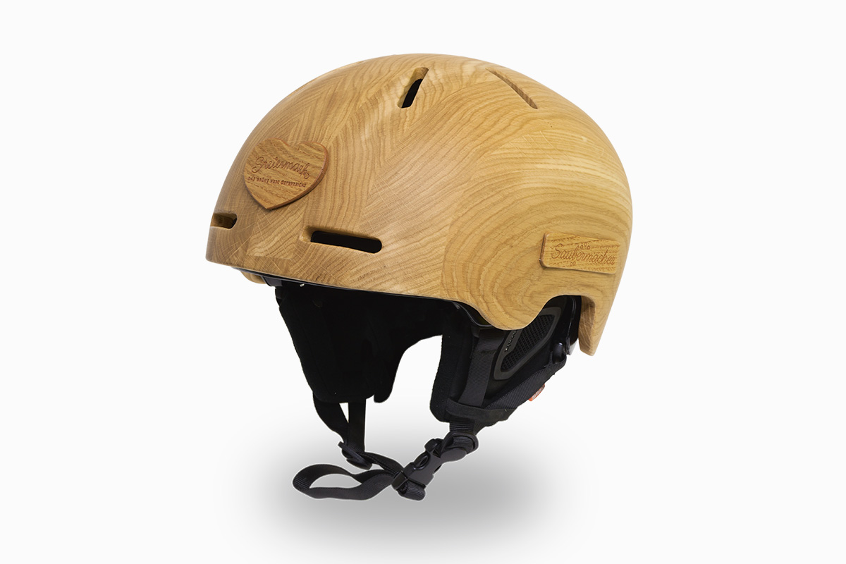 Auf dem weißen Hintergrund ist ein (Ski-)Helm mit besonderer Materialauswahl zu sehen. Der Helm, zum Teil gefertigt aus Eichenholz, steht für die steirische Eiche.